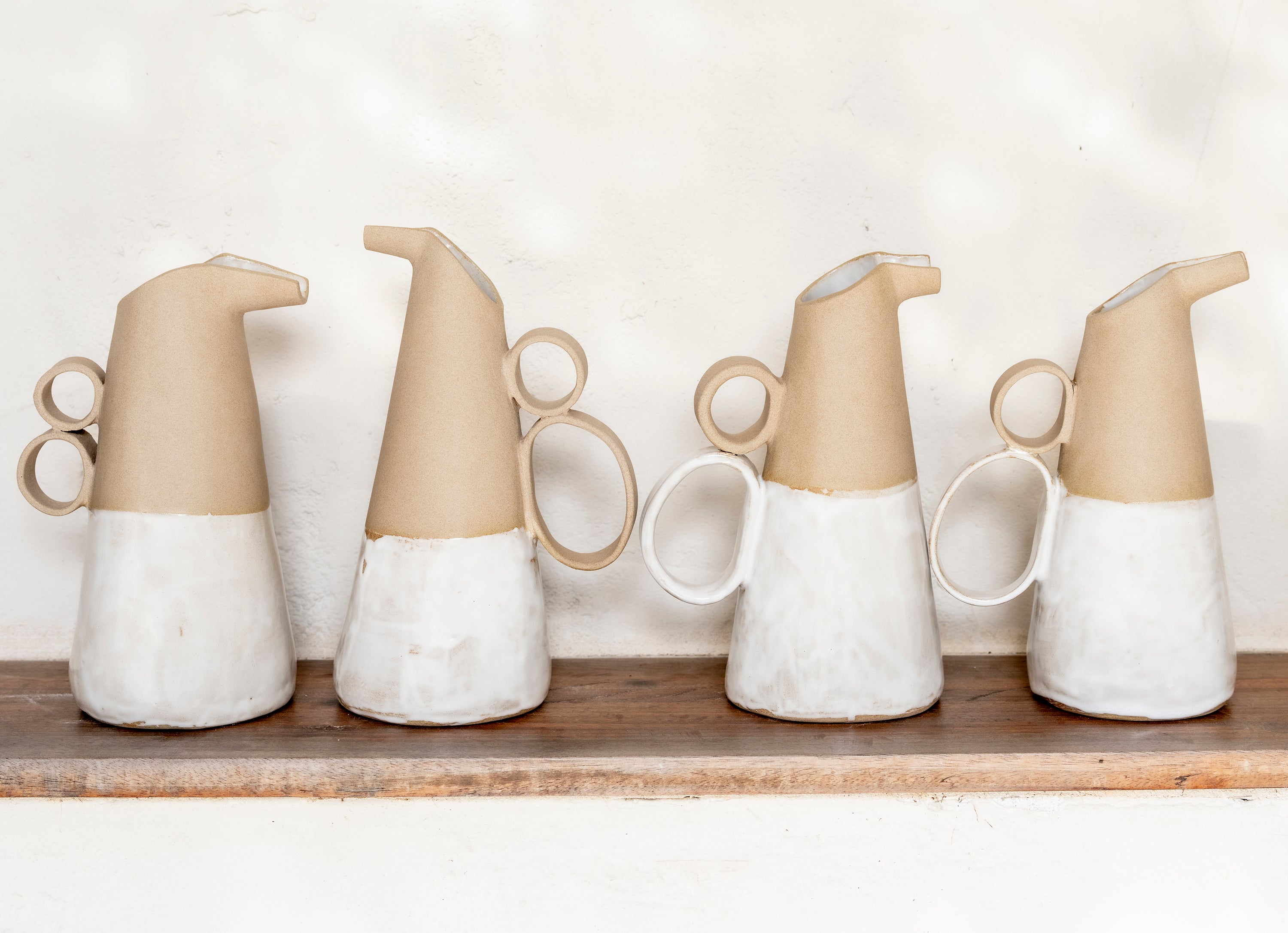 Bird-like ceramic pitchers balancing sculpture, utility and character.