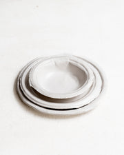     Handmade white stoneware dishes with irregular paper-like edges
* Contemporary stoneware tableware inspired by disposable paper plates
* Sculptural handmade ceramic dishes by Casa Retortillo
* Organic stoneware dish set photographed on neutral background
* Minimal handmade stoneware from the Arqueologies collection