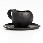     Handmade black stoneware coffee cup and saucer with white line detail.