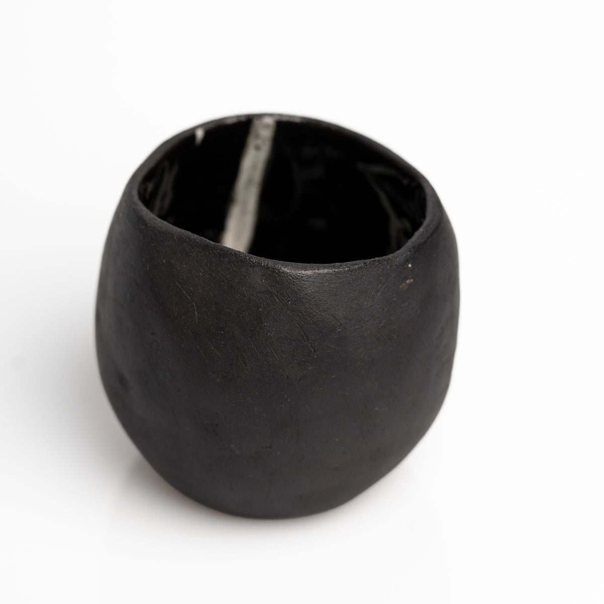     Handmade black stoneware sake cups with matte exterior and glossy glazed interior.