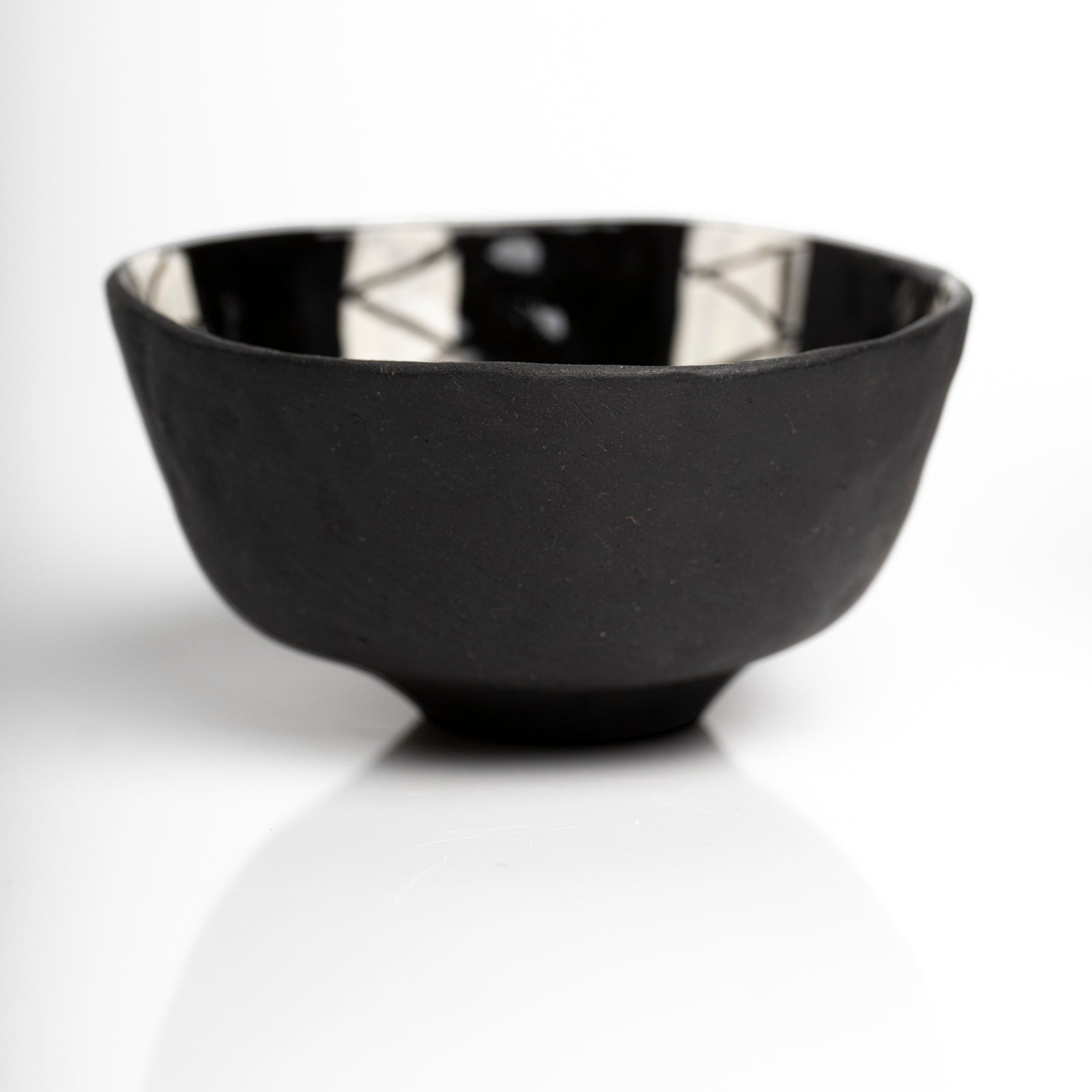     Handmade black stoneware snack bowl with unique hand-painted interiors.