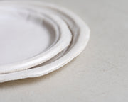     Handmade white stoneware dishes with irregular paper-like edges
* Contemporary stoneware tableware inspired by disposable paper plates
* Sculptural handmade ceramic dishes by Casa Retortillo
* Organic stoneware dish set photographed on neutral background
* Minimal handmade stoneware from the Arqueologies collection