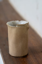     Handmade stoneware vase with corrugated textured surface
* Contemporary ceramic vessel inspired by cardboard packaging
* Sculptural handmade stoneware vase with irregular edges
* Organic textured ceramic object by Casa Retortillo
* Minimal stoneware vase from the Arqueologies collection