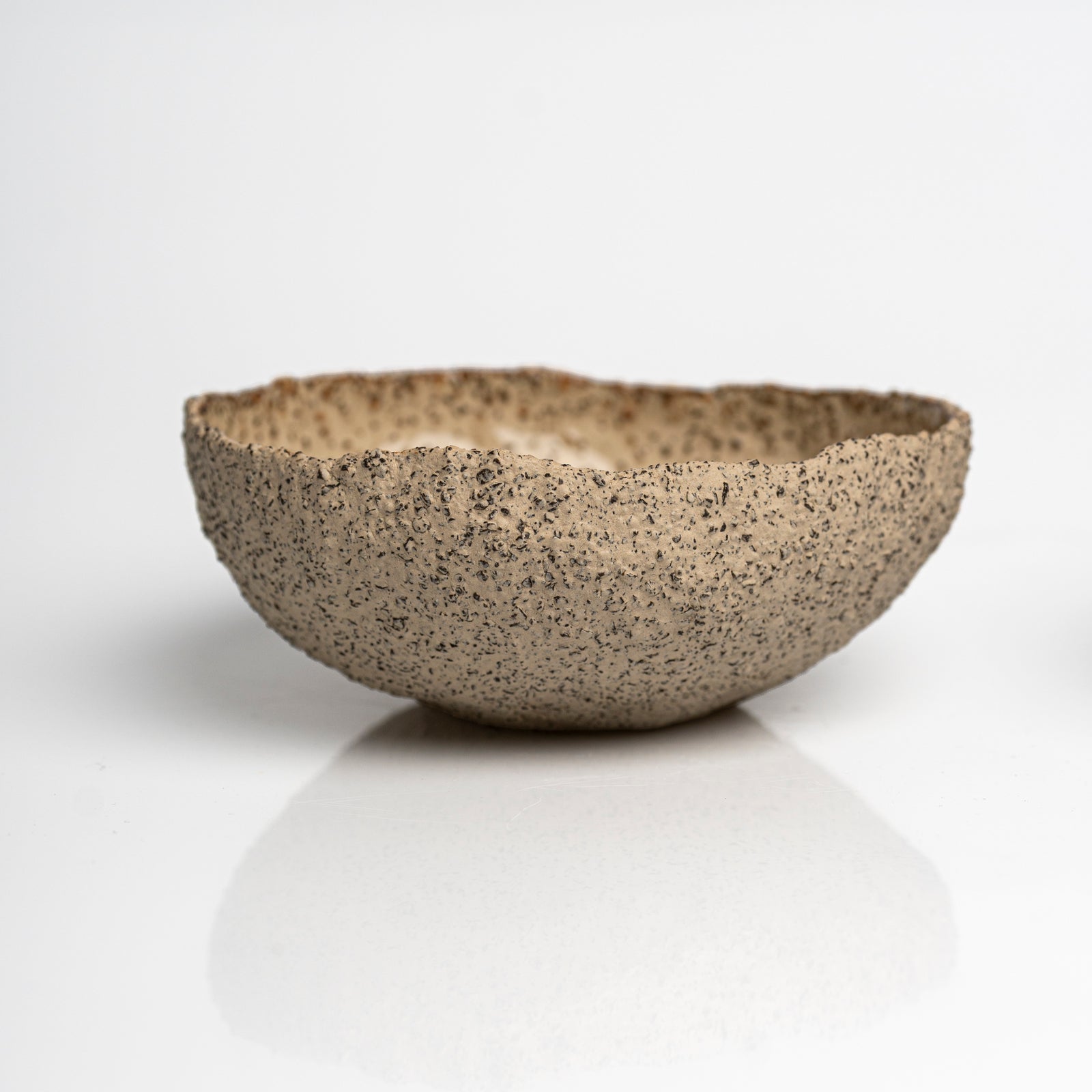     Handmade textured stoneware serving bowl with creamy glazed interior.