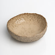 Handmade textured stoneware serving bowl with creamy glazed interior.
