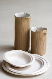     Handmade white stoneware dishes with irregular paper-like edges
* Contemporary stoneware tableware inspired by disposable paper plates
* Sculptural handmade ceramic dishes by Casa Retortillo
* Organic stoneware dish set photographed on neutral background
* Minimal handmade stoneware from the Arqueologies collection